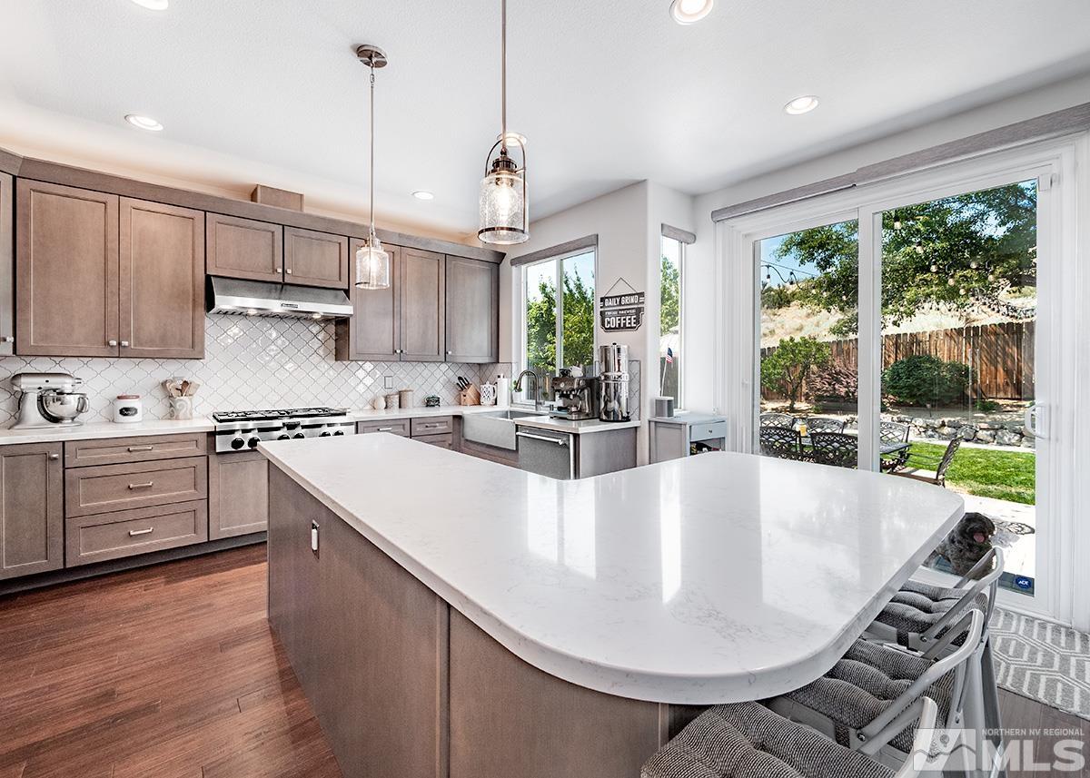 3095 Roxbury Drive Reno, NV 89523 - Photo 7 of 36 a large kitchen with kitchen island a stove a sink a center island and windows