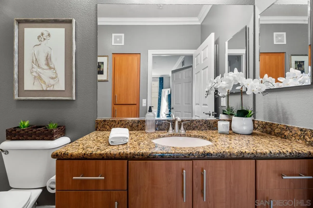 1400 Broadway, Unit 1505 San Diego, CA 92101 - Photo 14 of 34 a bathroom with a granite countertop sink and a mirror