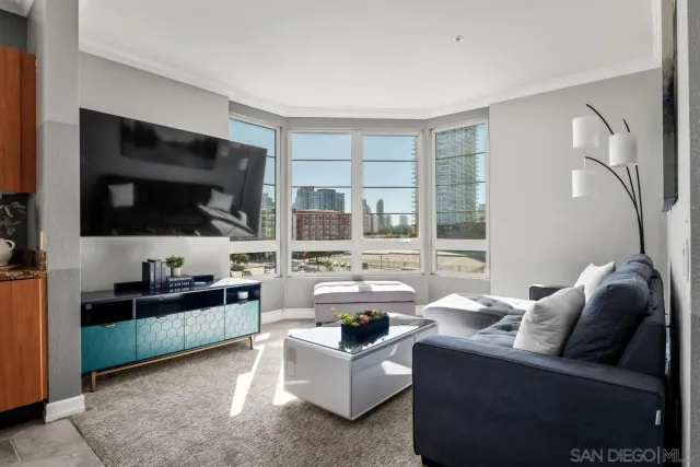 a living room with furniture a flat screen tv and a window