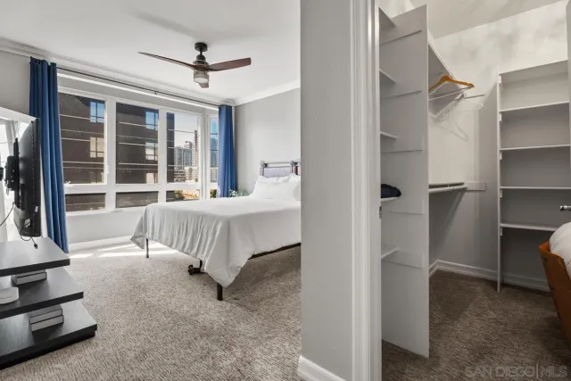 a bedroom with a bed tv and a large window