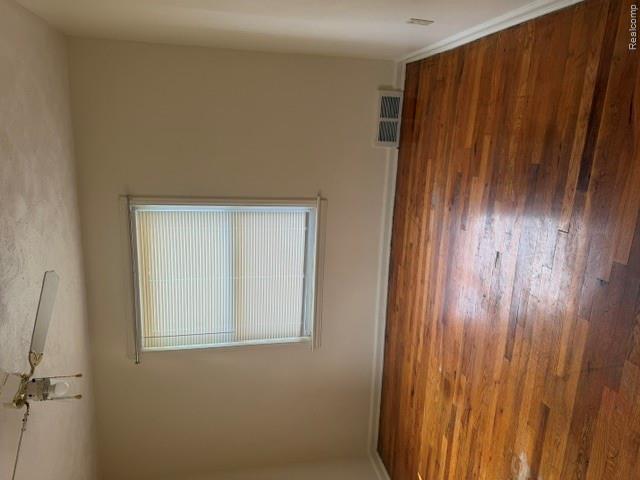 8144 Meyers Road Detroit, MI 48228 - Photo 15 of 19 Room featuring wood flooring, white baseboards, a window with horizontal blinds, a ceiling fan with light fixture, and a wall vent