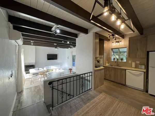a living room with furniture a fireplace and a dining table with wooden floor
