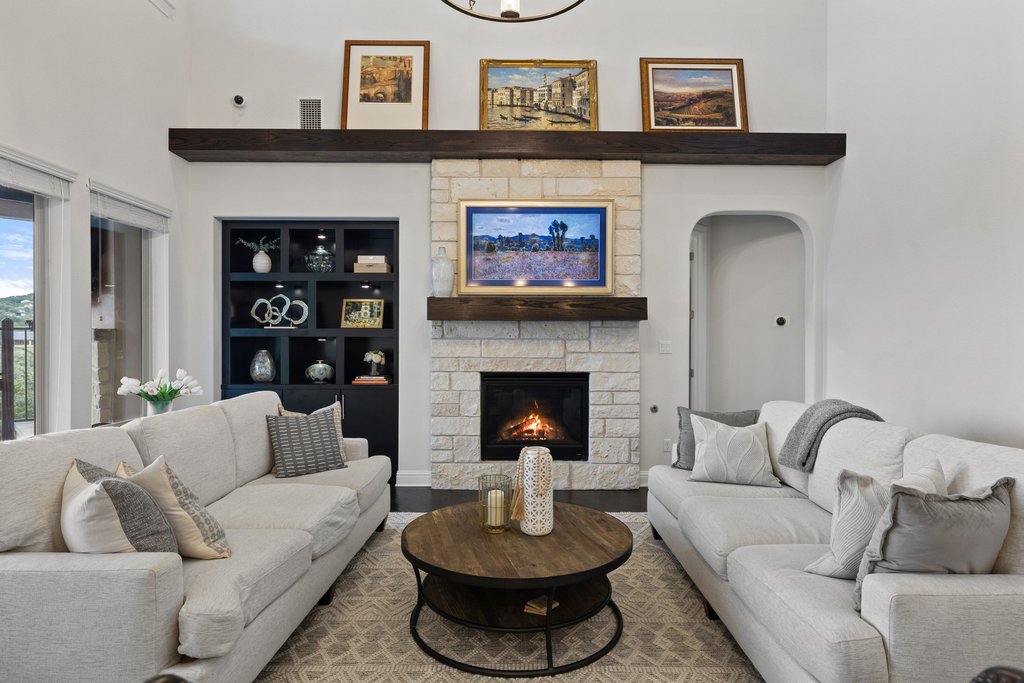 215 Lodestone Lane Austin, TX 78738 - Photo 15 of 40 A striking stone fireplace creates a cozy focal point in this sun-filled living area.