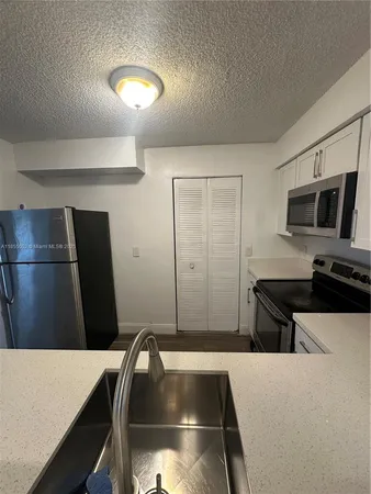 a kitchen with a refrigerator and a sink
