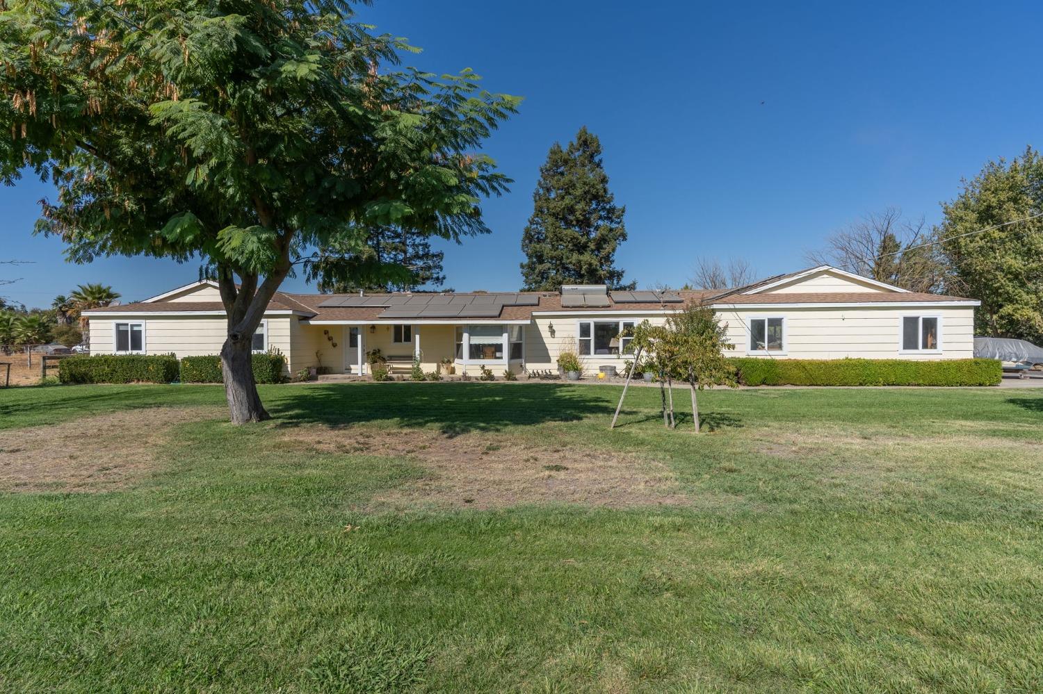 6513 River Road Oakdale, CA 95361 - Photo 1 of 1 a front view of a house with a garden