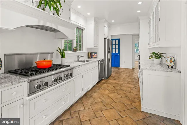 a kitchen with stainless steel appliances granite countertop a stove a sink and a refrigerator