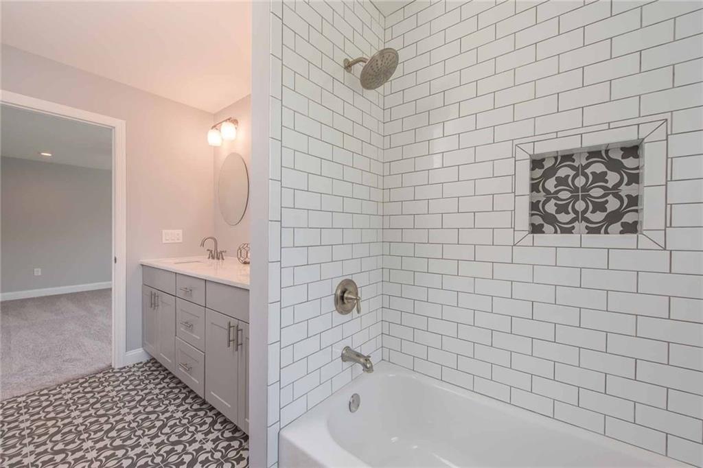 226 McCoy Place Road Sewickley, PA 15143 - Photo 22 of 25 Bringing the floor tile into the shower niche adds a touch of sophistication in this white subway tile surround.