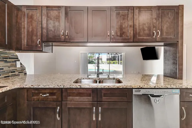 a kitchen with granite countertop cabinets and window