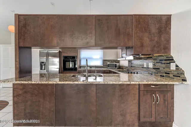 a kitchen with kitchen island granite countertop a sink and a stove