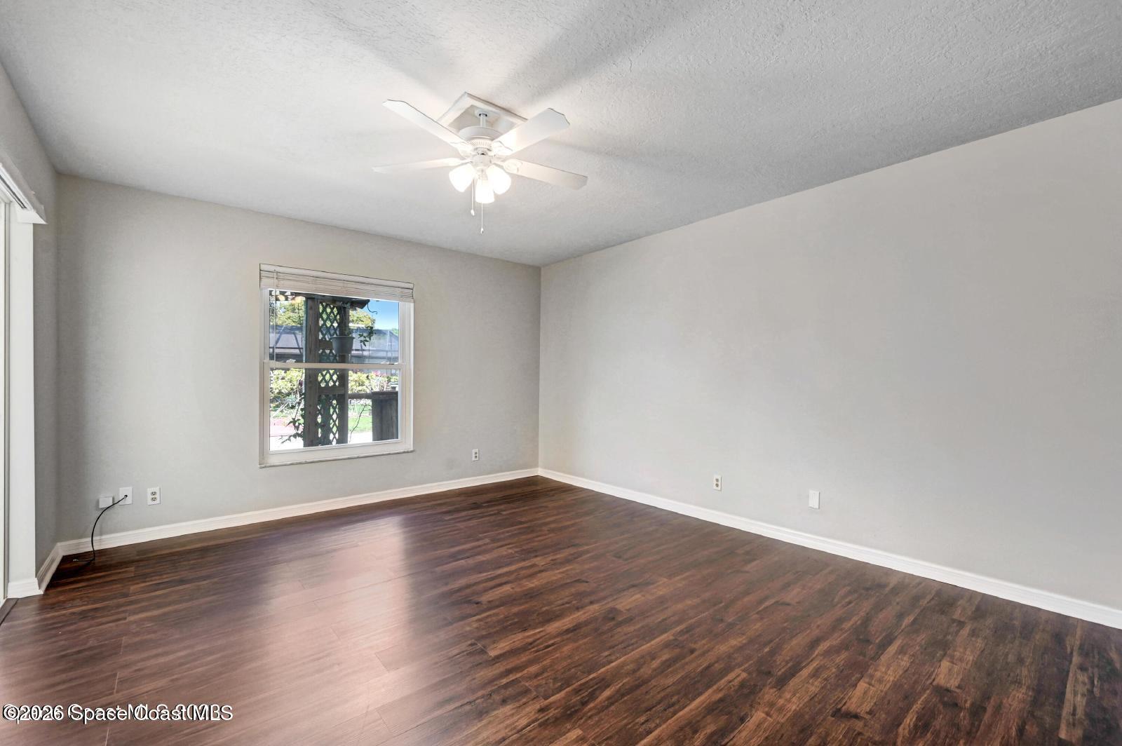 296 Sandy Run Melbourne, FL 32940 - Photo 10 of 23 a view of an empty room with wooden floor and a window