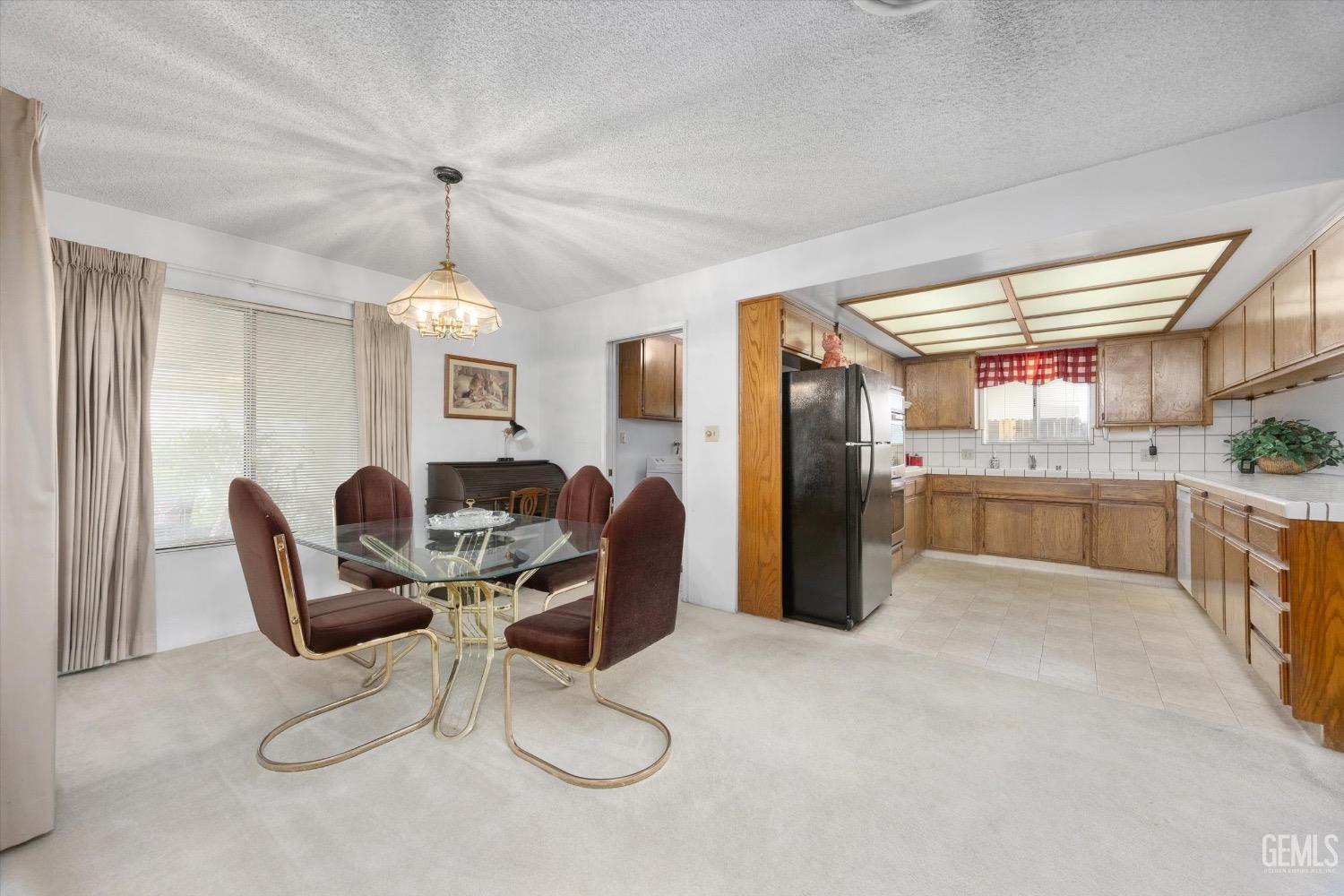 Undisclosed Address Bakersfield, CA 93311 - Photo 11 of 35 a kitchen with stainless steel appliances kitchen island granite countertop a refrigerator a stove a sink dishwasher with a dining table and chairs