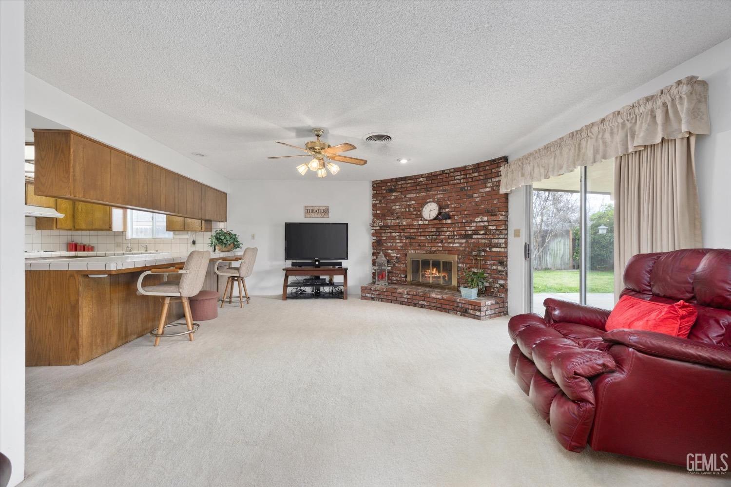 Undisclosed Address Bakersfield, CA 93311 - Photo 12 of 35 a living room with furniture a flat screen tv and a floor to ceiling window