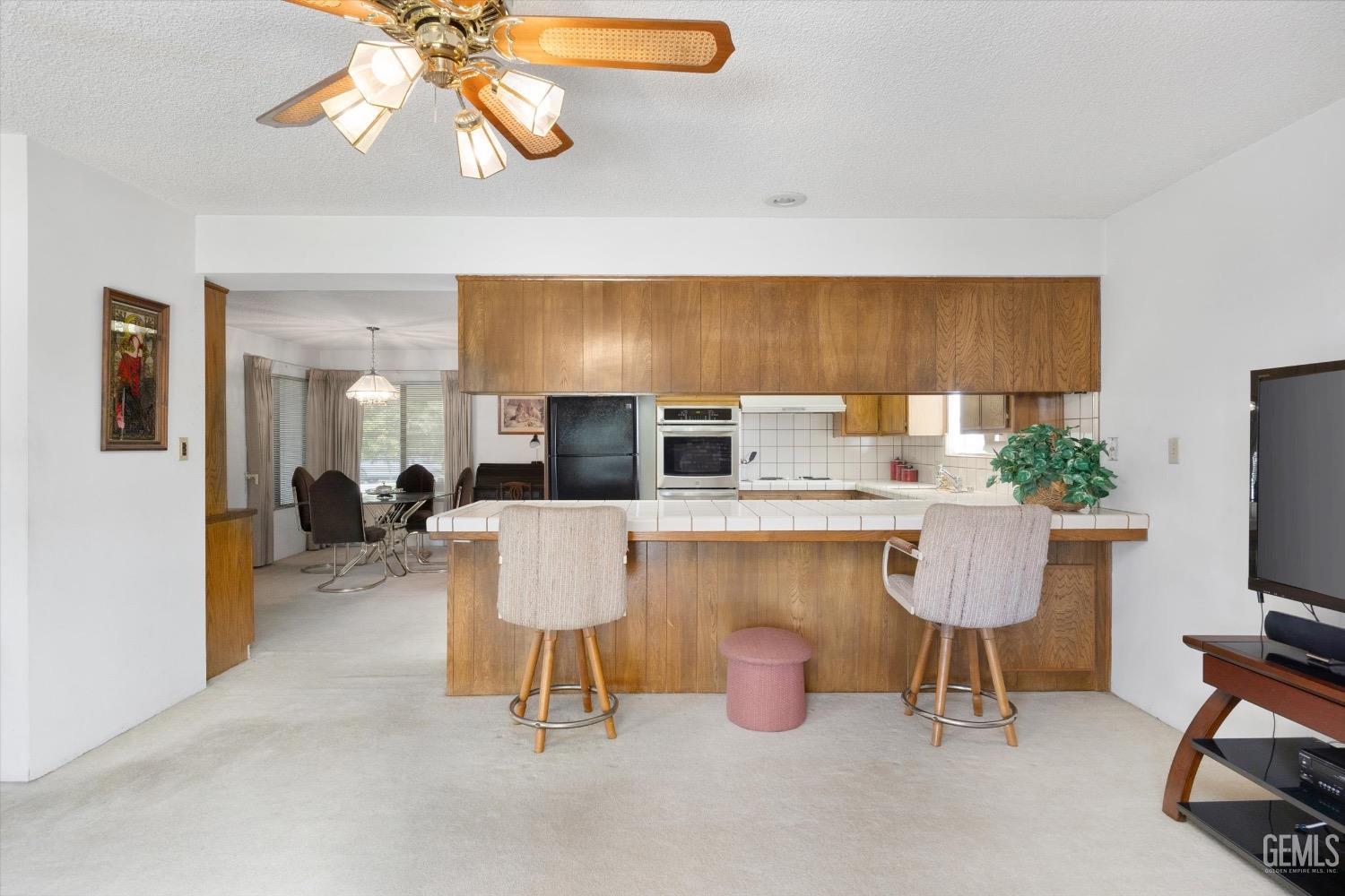 Undisclosed Address Bakersfield, CA 93311 - Photo 15 of 35 a living room with furniture a flat screen tv and kitchen area