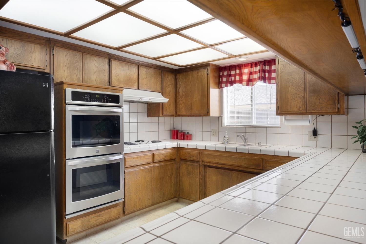 Undisclosed Address Bakersfield, CA 93311 - Photo 17 of 35 a kitchen with a sink cabinets stainless steel appliances and a window