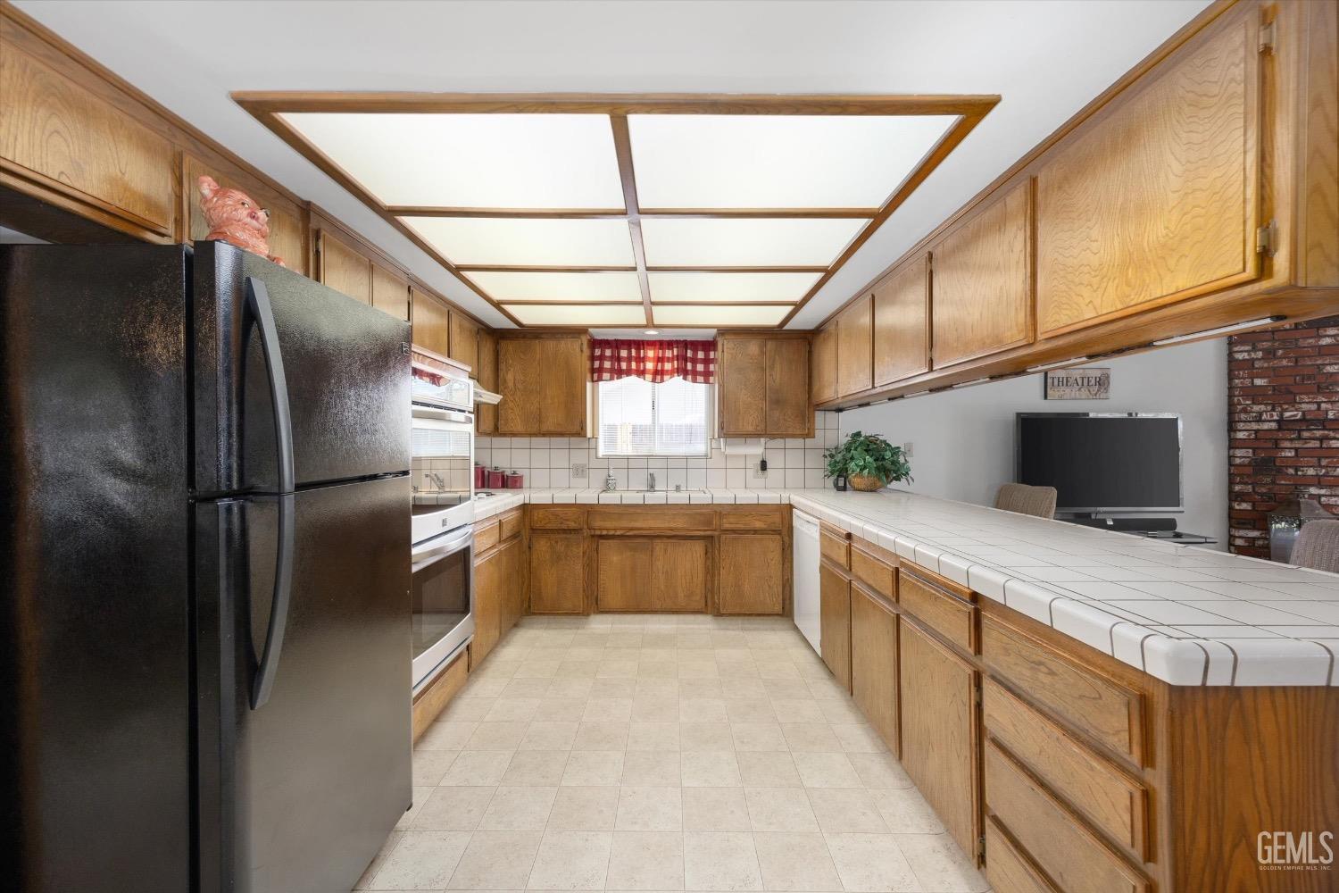 Undisclosed Address Bakersfield, CA 93311 - Photo 18 of 35 a large kitchen with stainless steel appliances kitchen island granite countertop a refrigerator a sink a stove and washer