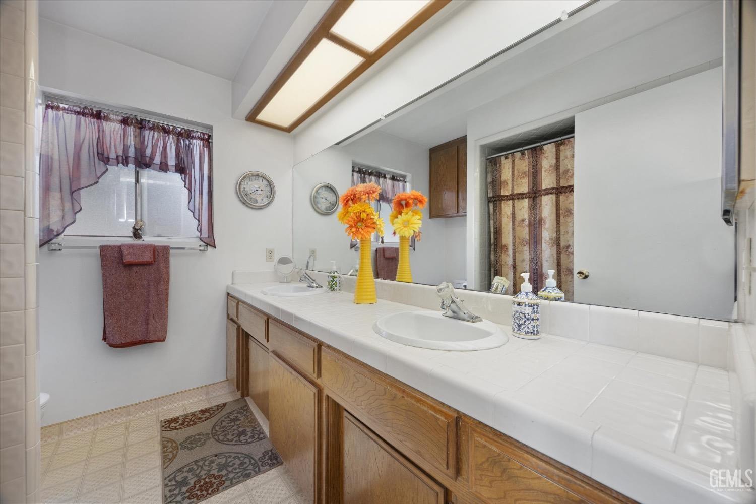 Undisclosed Address Bakersfield, CA 93311 - Photo 21 of 35 a bathroom with a sink a vanity and a large mirror