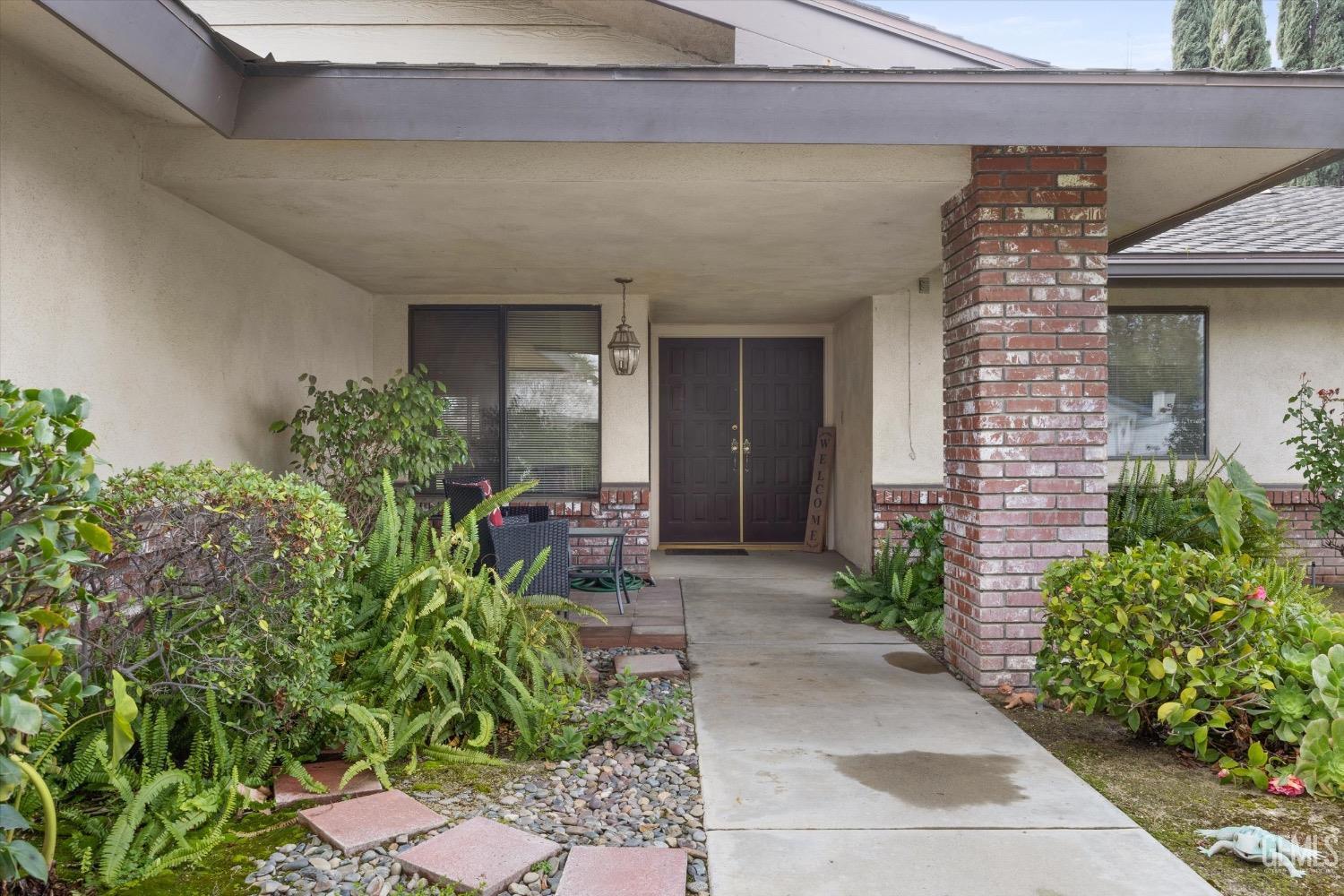 Undisclosed Address Bakersfield, CA 93311 - Photo 4 of 35 a view of a house with potted plants and a bench