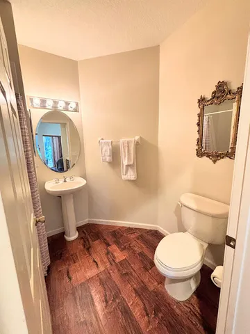 a bathroom with a toilet a sink and mirror