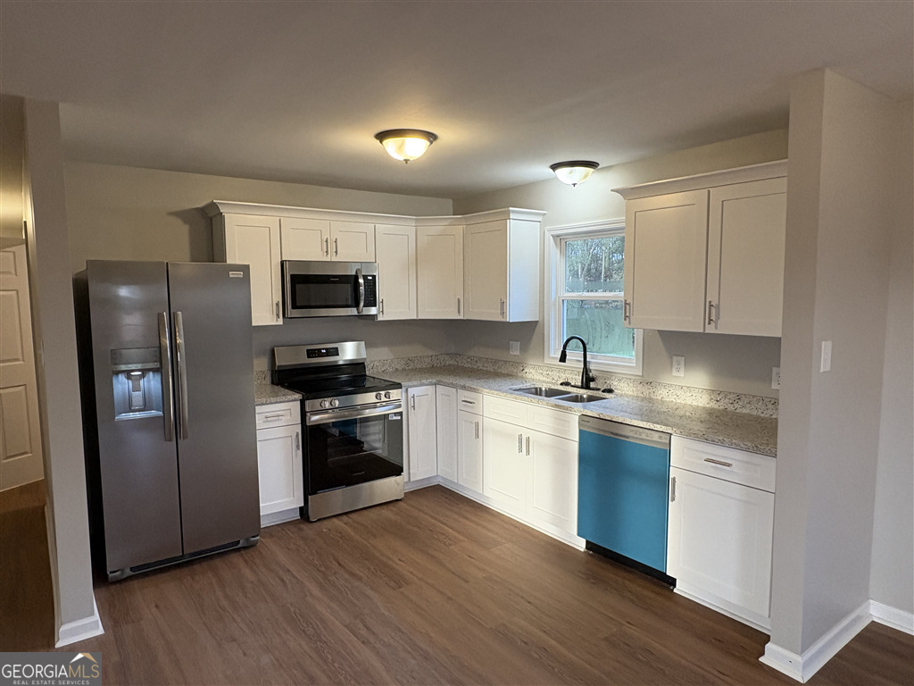 358 Misty Mills Road Lavonia, GA 30553 - Photo 4 of 7 a kitchen with granite countertop a refrigerator stove and sink