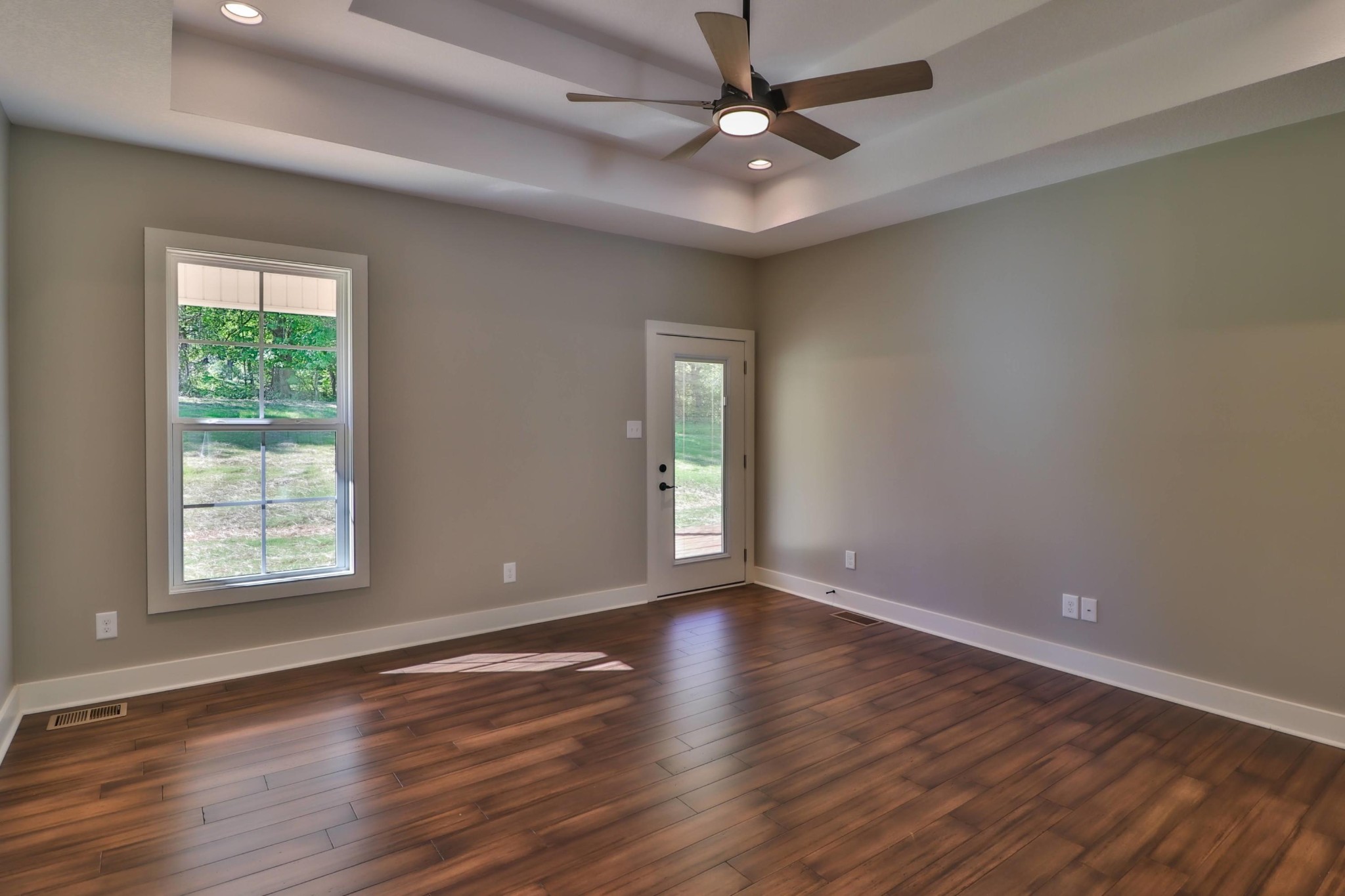3423 West Wolf Valley Road Clinton, TN 37716 - Photo 16 of 34 an empty room with wooden floor chandelier fan and windows