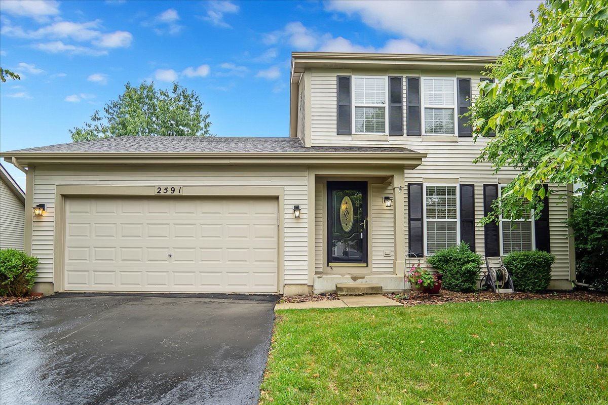 a front view of a house with a yard and garage