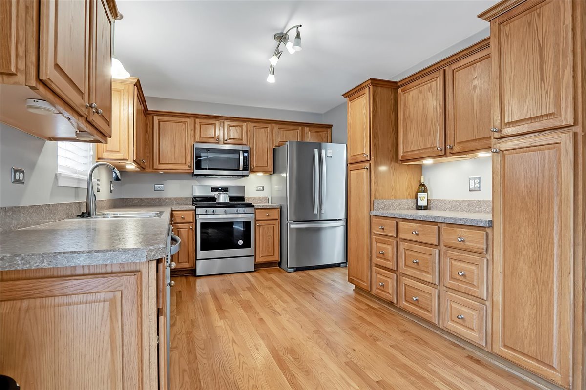2591 Smithfield Lane Aurora, IL 60503 - Photo 4 of 31 a kitchen with granite countertop a refrigerator sink and cabinets