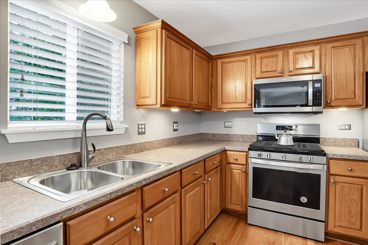 2591 Smithfield Lane Aurora, IL 60503 - Photo 5 of 31 a kitchen with granite countertop a sink stainless steel appliances and cabinets