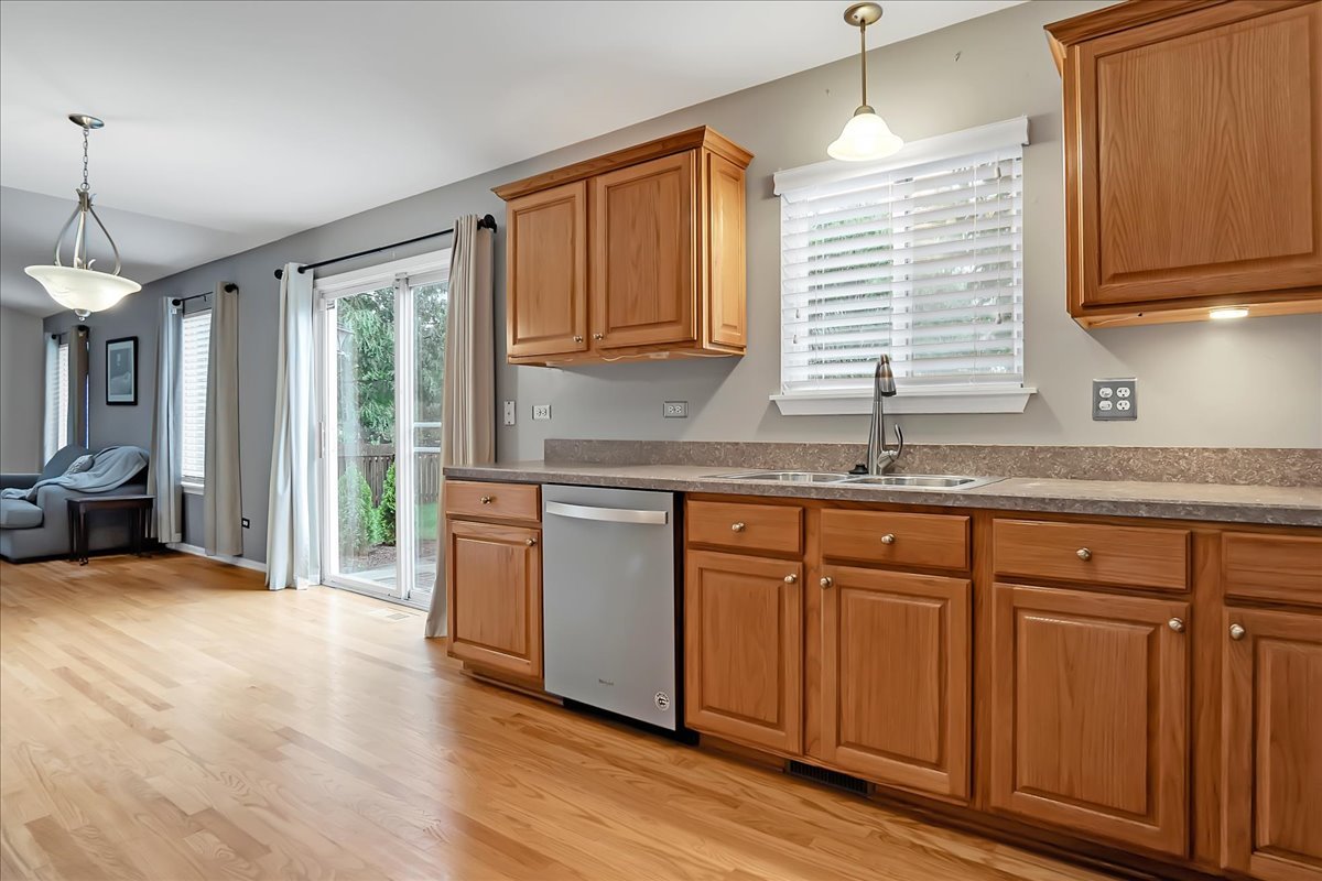 2591 Smithfield Lane Aurora, IL 60503 - Photo 6 of 31 a kitchen with stainless steel appliances granite countertop a sink a stove cabinets and wooden floor