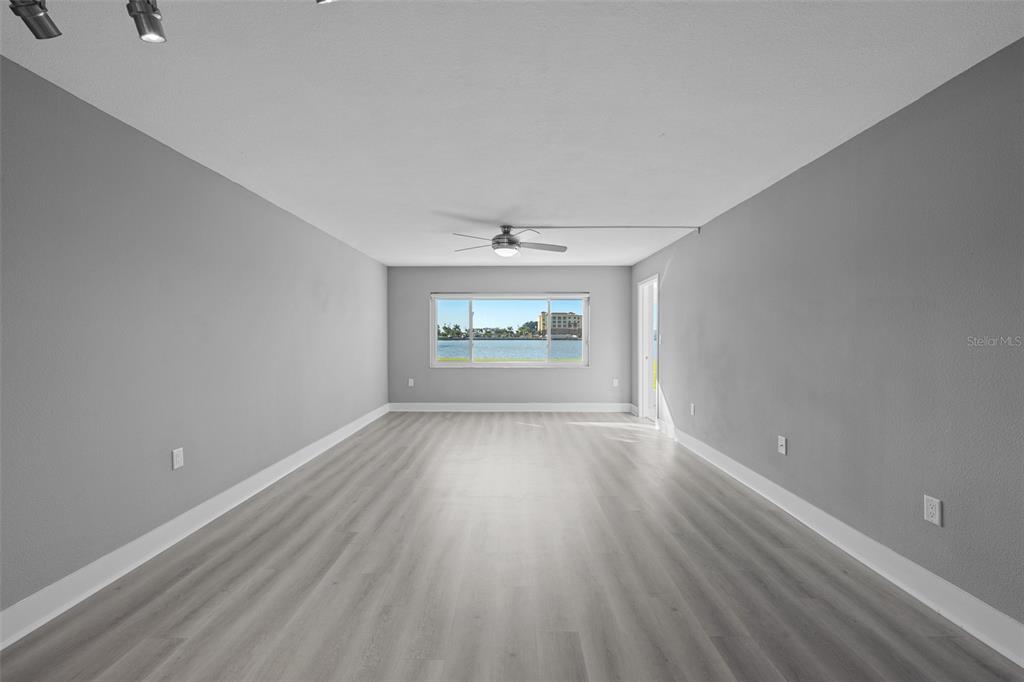 4775 Cove Circle, Unit 103 St. Petersburg, FL 33708 - Photo 12 of 61 wooden floor in an empty room with a window