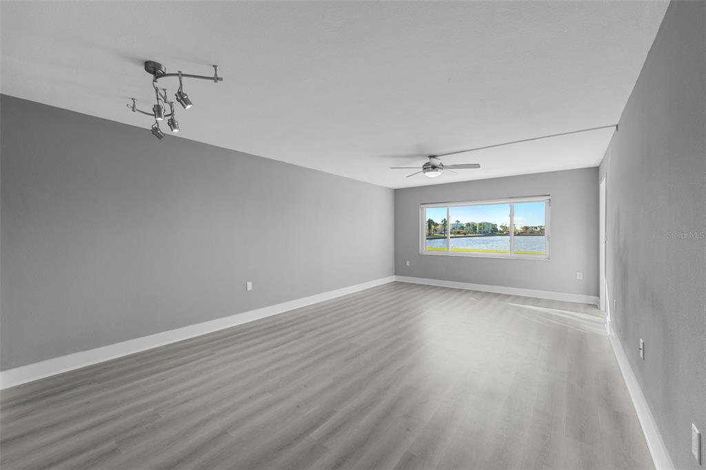 4775 Cove Circle, Unit 103 St. Petersburg, FL 33708 - Photo 14 of 61 wooden floor in an empty room with a window
