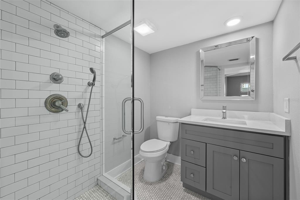 4775 Cove Circle, Unit 103 St. Petersburg, FL 33708 - Photo 19 of 61 a bathroom with a granite countertop sink toilet and shower