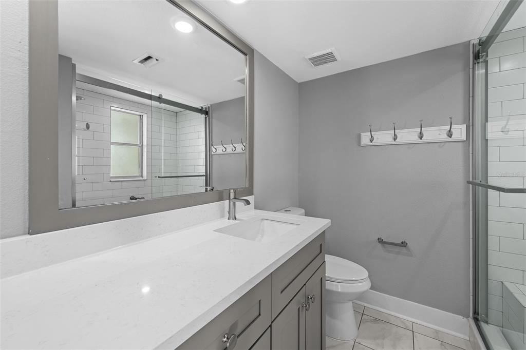4775 Cove Circle, Unit 103 St. Petersburg, FL 33708 - Photo 27 of 61 a bathroom with a sink a toilet and mirror