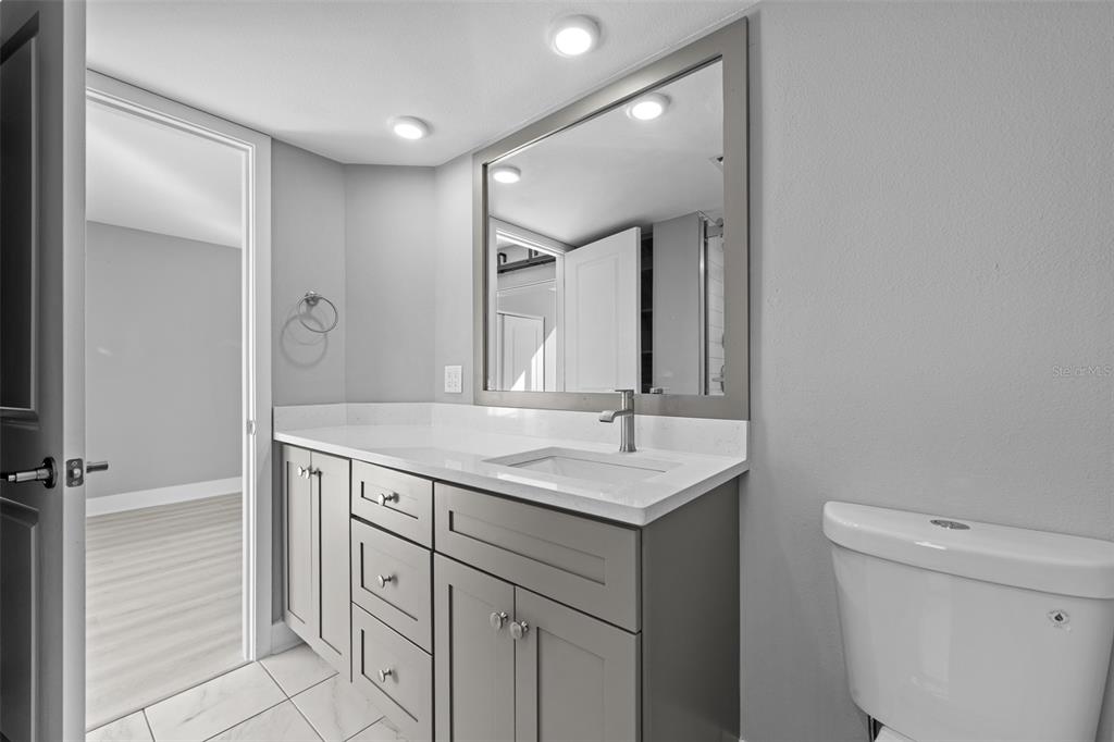 4775 Cove Circle, Unit 103 St. Petersburg, FL 33708 - Photo 28 of 61 a bathroom with a sink a toilet and a mirror