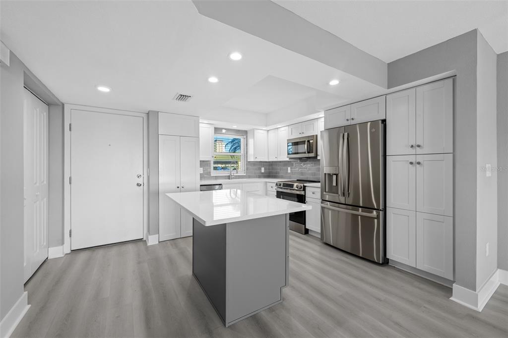 4775 Cove Circle, Unit 103 St. Petersburg, FL 33708 - Photo 3 of 61 a kitchen with refrigerator and wooden floor