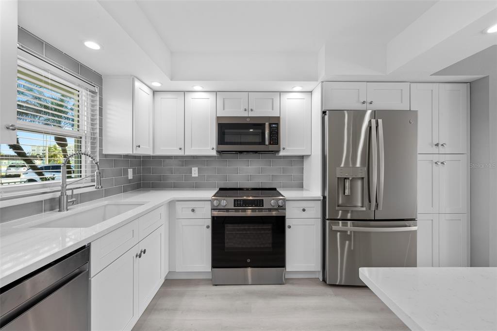4775 Cove Circle, Unit 103 St. Petersburg, FL 33708 - Photo 6 of 61 a kitchen with a refrigerator and a sink