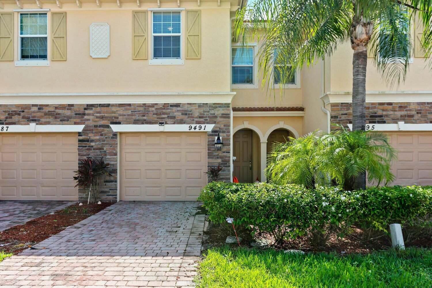 9491 Southwest Merlin Court Stuart, FL 34997 - Photo 3 of 45 a front view of a house with a yard and garage