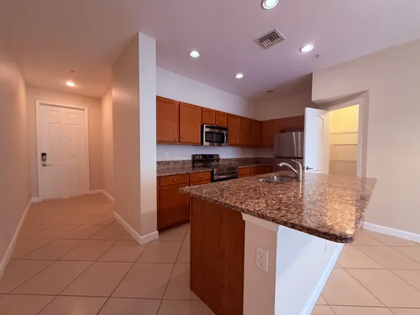 a view of an empty room with wooden floor and closet