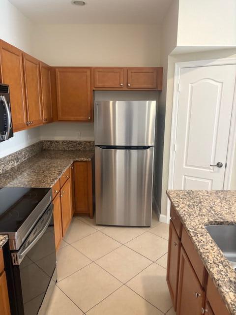 9491 Southwest Merlin Court Stuart, FL 34997 - Photo 10 of 45 a kitchen with granite countertop a refrigerator and a sink