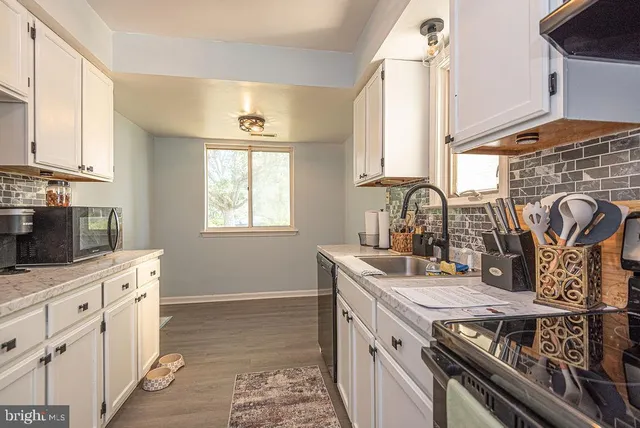 a kitchen with stainless steel appliances granite countertop a sink stove and cabinets