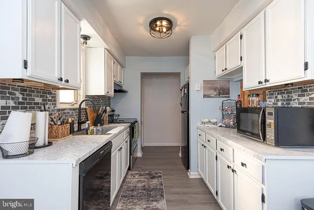 a kitchen with stainless steel appliances a stove a sink a microwave a refrigerator and cabinets