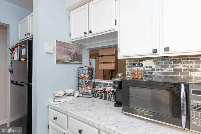 a kitchen with stainless steel appliances granite countertop a refrigerator and a stove