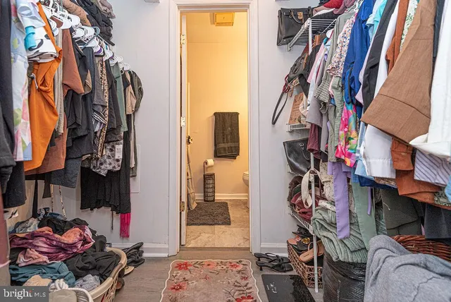 a view of walk in closet with clothes and shoes