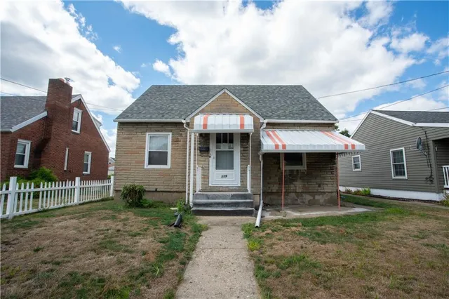 a front view of a house with a garden