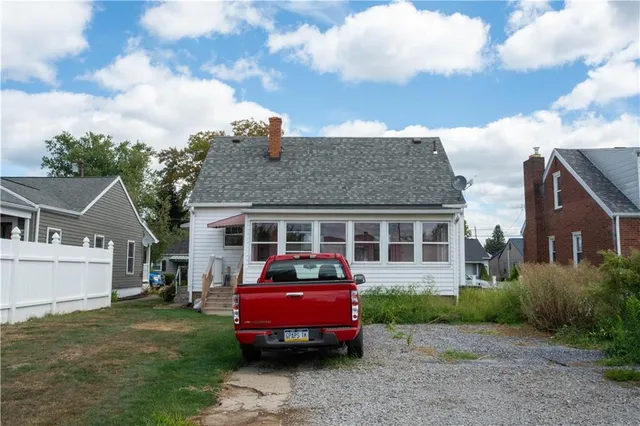 a front view of a house with a garden and barbeque oven
