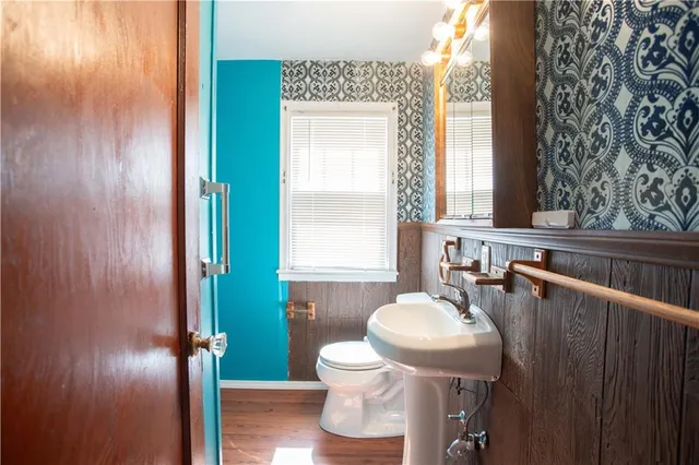 a bathroom with a toilet a sink and mirror