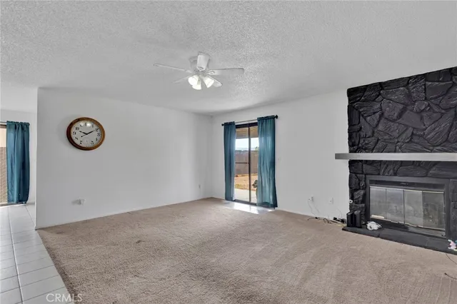 an empty room with windows and fireplace