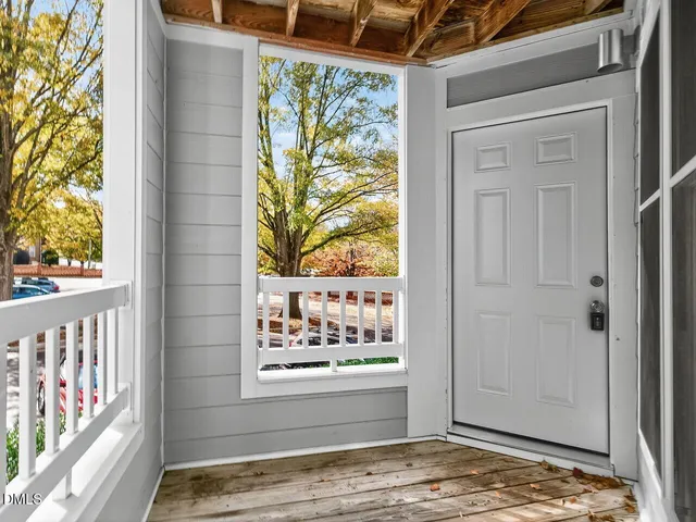 an empty room with wooden floor fireplace and windows