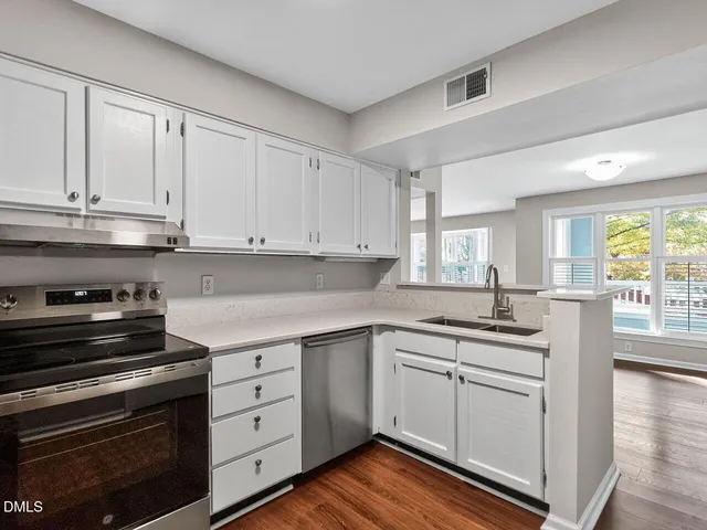 a kitchen with granite countertop white cabinets and stainless steel appliances