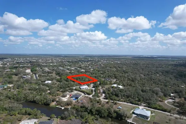 an aerial view of a house with a yard and mountain view in back