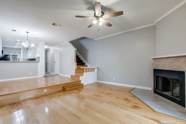 an empty room with windows and fireplace